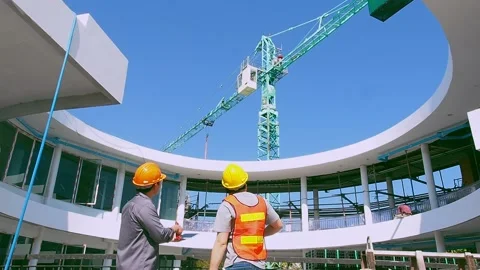 Two young engineer and architect standing in front of mechanical crane Stock Footage 231774795