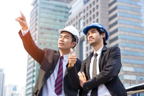 Two young engineers discuss the structure and points to a site that creates.. Stock Photos