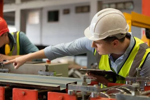 Two young engineers Testing and verifying the operation of the machines fo... Stock Photos