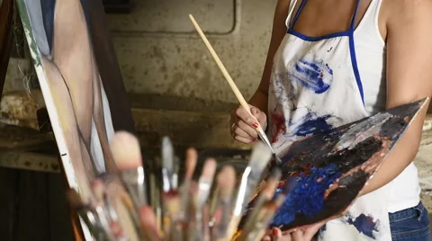 Two young female art students helping eachother and laughing Stock Footage 55313877