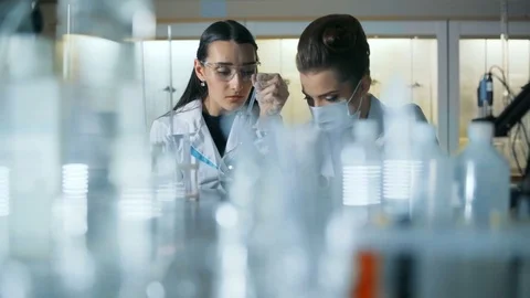 Two young female scientist doing experiments in lab Stockbeeldmateriaal 69945154