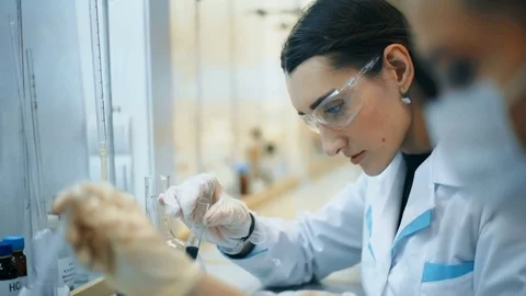Two young female scientist doing experiments in lab Stock Footage