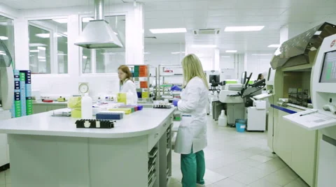 Two Young Female Scientists in White Coats and Rubber Gloves Are Working in a Stock-Footage 61006607