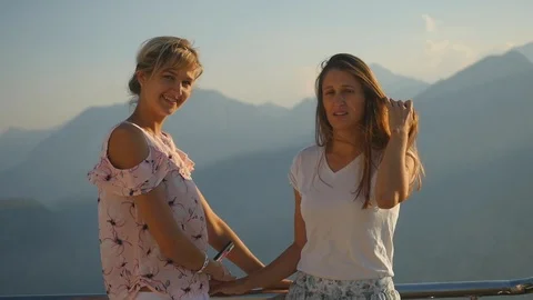Two young female taking self-portrait pictures in the view from the top of a mou Stock Footage 96225339