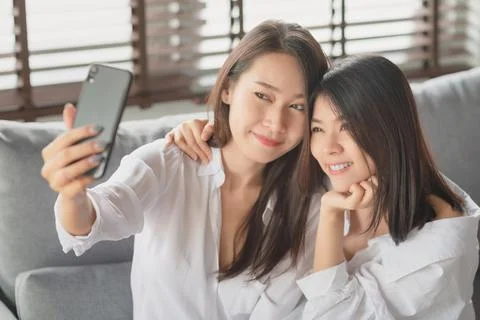 Two young female using mobile phone and internet technology to use video call Stock Photos