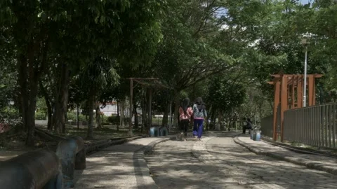 Two young female walk inside the empty public park due COVID-19 Stock Footage 139374494