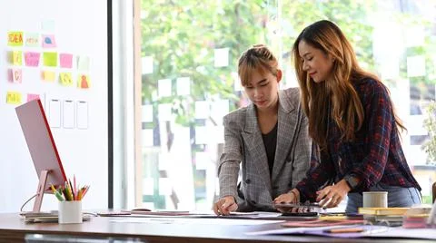 Two young female web developer brainstorming, working together on mobile Stockfoto's