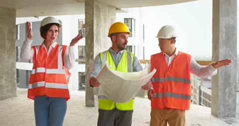Two young foremen go along construction site and look at the blueprint Stock Footage 172286930