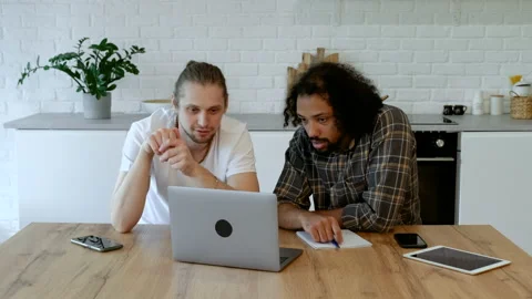 Two Young Freelance Guys Work Remotely At Home on an Online Project Stock Footage 165664947