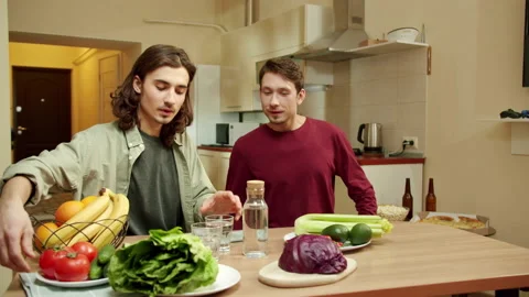 Two young friends are sitting at the table and talking to each other Stock Footage 159365397