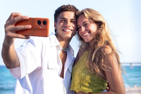 Two young friends on the beach doing a self portrait with the smartphone. Foto stock