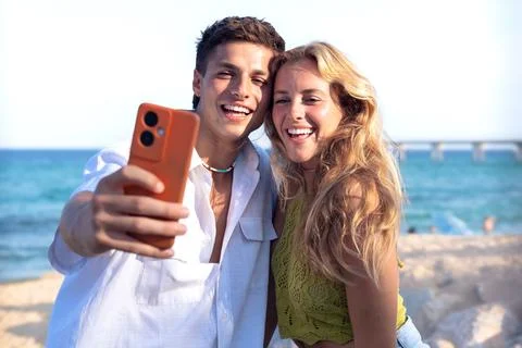 Two young friends on the beach doing a self portrait with the smartphone. Stock-Fotos