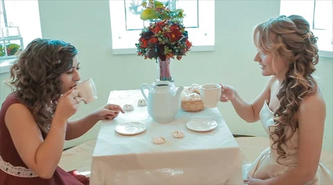 Two Young Friends Drink Tea at Table Slow Motion Stock Footage 68689455