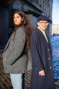 Two young friends posing back to back, North African woman and Danish man, .. Stock Photos