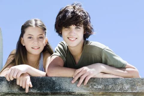 Two young friends standing side by side, smiling at camera, portrait Stock Photos
