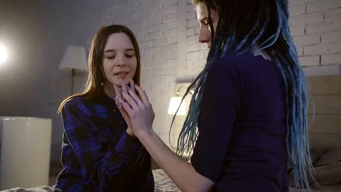 Two young friends touch one another with their hands, informal girls enjoy Stock Footage 84251737