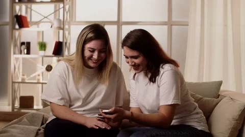 Two young friends in white t-shirts have fun. Two attractive young girls Video stock 244120625