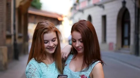 Two young girl using GPS in mobile phone. Old town backbround Stock Footage 55142628