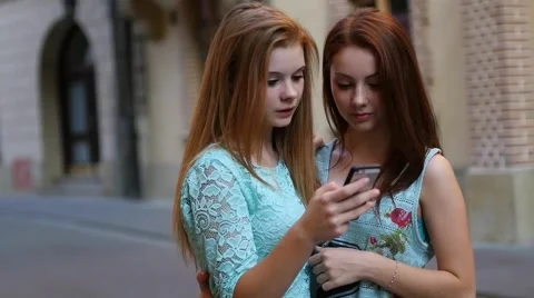Two young girl using GPS in mobile phone. Old town backbround. Stock Footage 55142682