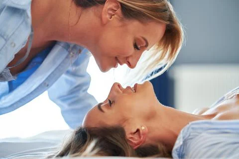 Two young girlfriends on the bed Stock Photos