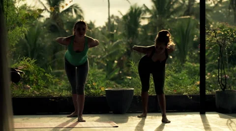 Two young girlfriends on terrace exercising yoga, doing bend Stock Footage 53249665