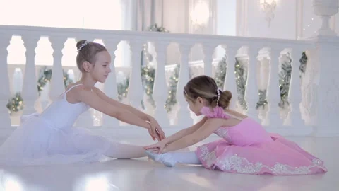 Two young girls are practicing ballet on a white floor Stock Footage 300660814