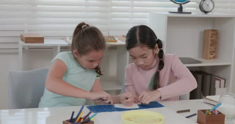 Two Young Girls Collaborating On Creative Art Project With Crayons At Table.. Stock Footage 337086295