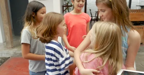 Two young girls high five and join their diverse group of mixed racial friends Stock Footage 85355859