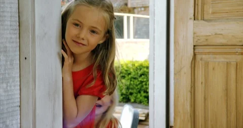 Two young girls peering inside an open door. Vidéo 88377092