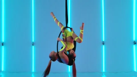 Two young girls perform acrobatic elements on an air hoop. Aerial acrobats in a Stock Footage 146618342
