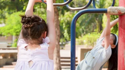 Two Young Girls Playing on Monkey Bars at Lumpini Park Stock Footage 342714233