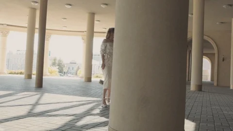 Two young girls posing in front of the camera on the background of architectural Stock Footage 104480291