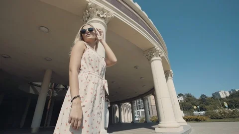 Two young girls posing in front of the camera on the background of architecture. Stock Footage 104480345