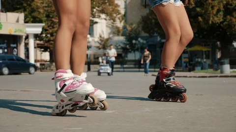 Two young girls rollerblading on the square in the city Stock Footage 115507084