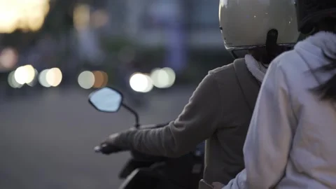 Two young girls on a scooter, two women are standing happily, holding a scooter Stock Footage 239761920