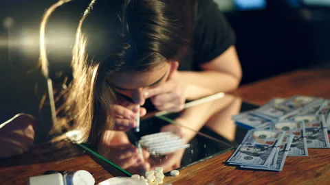 Two young girls snorting an illegal white powder with rolled up dollar bills. Stock Footage 87129253