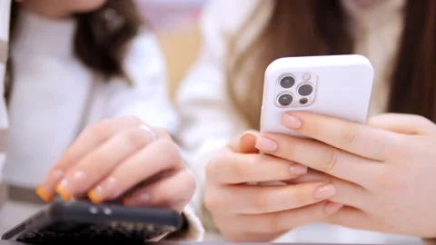 Two young girls using mobile phones while sitting at the cafe indoors mall. Two Stock Footage 270657115