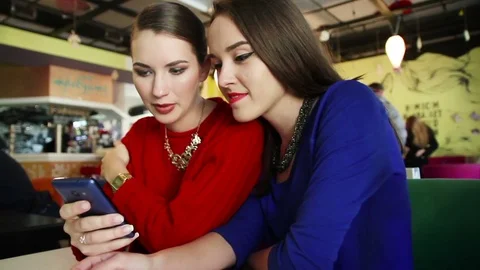 Two young girls using smart phone at the cafe. Stock Footage 70467208