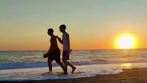  Two Young Guys are Walking on the Beach at Sunset in Calabria, Italy. Stock Footage 231141540