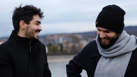 Two young guys with beards next to a river have a nice conversation. Stock Footage 103310207