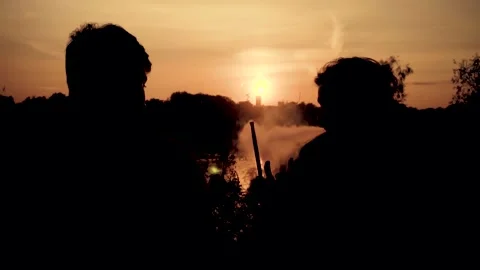 Two young guys smoke a hookah on a sunset background. Vidéo 160756231