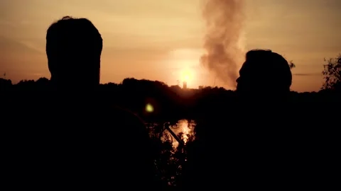 Two young guys smoke a hookah on a sunset background. Video stock 160757032