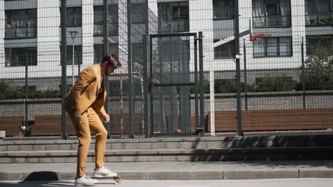 Two young guys in suit walking city with skateboard,laughing smiling,high five Stock Footage 147473672