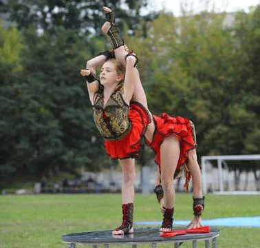 Two young gymnasts performing a complex acrobatic handstand balance on a stag Stock Photos