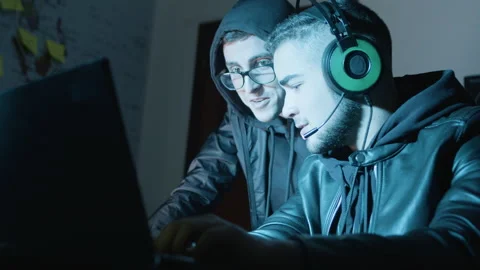 Two young hackers working in dark room at night Stock Footage 181840634