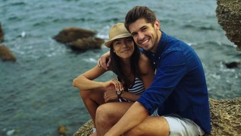 Two young happy people posing on the beach and smiling on camera Stock Footage 70371263