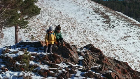 Two young hikers exploring snowy mountain peak 스톡 동영상 302812453