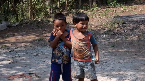 Two young hispanic children standing with arms around each other in Guatemala Stock Footage 125957350