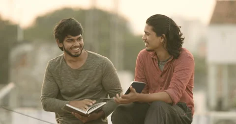 Two young Indian collage students studying on terrace Stock Footage 157167097