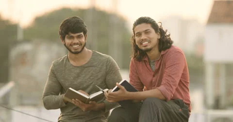 Two young Indian collage students studying on terrace Stock Footage 157167179